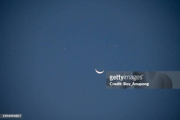 the smile in the sky. the unusual phenomenon, with venus as the left eye and jupiter the right over crescent moon. - 壮大な景観 ストックフォトと画像
