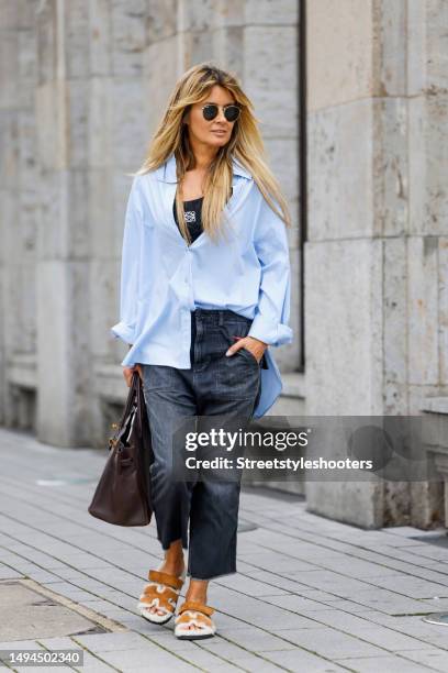 Influencer Gitta Banko, wearing a black top by Loewe, a light blue blouse by Boscana, a dark blue jeans by Nili Lotan, sandals by Hermes, a brown bag...