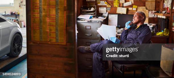 female garage owner with paperwork - small business stock pictures, royalty-free photos & images