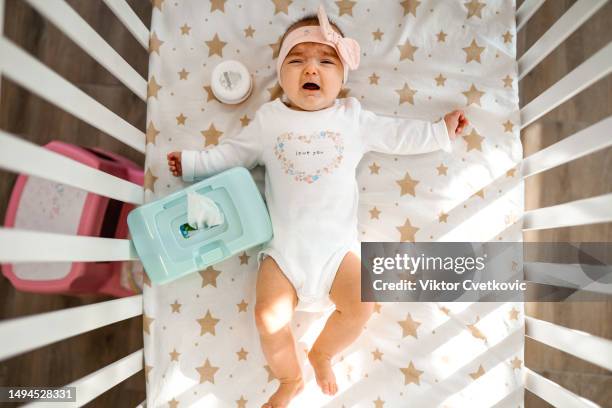 baby girl crying in a crib - baby wipes stock pictures, royalty-free photos & images