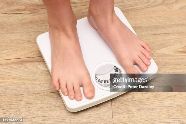 overweight boy on scales - childhood obesity stock pictures, royalty-free photos & images