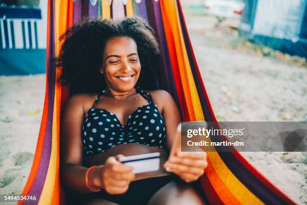 woman in hammock is shopping online - swimwear shopping stock pictures, royalty-free photos & images