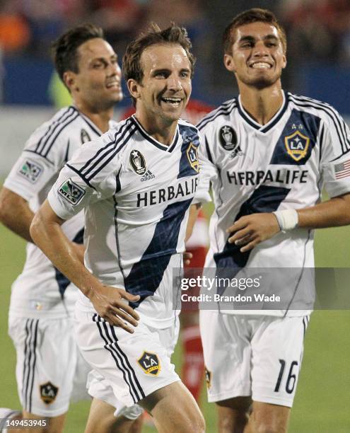 Mike Magee of the Los Angeles Galaxy celebrates with teammates Hector Jimenez and Marcelo Sarvas, left, after scoring a goal during the second half...