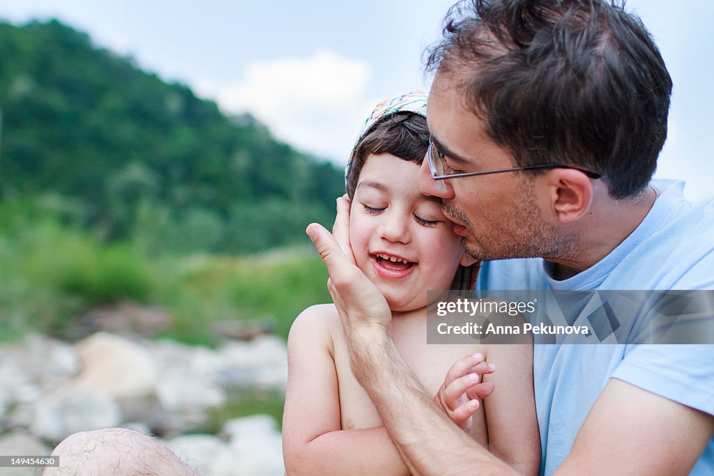 Father holding and kissing his son