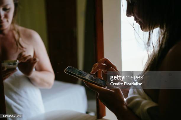 woman in the hotel room with mobile phone by the mirror - female worried mobile imagens e fotografias de stock