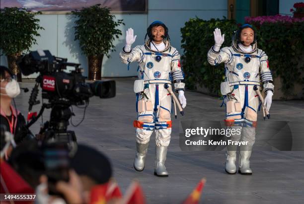 Chinese Shenzhou-16 mission astronaut and first civilian Gui Haichao waves next to mission lead Jing Haipeng at a pre-launch departure ceremony early...