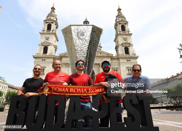 Roma and Sevilla FC supporters pose with a large replica of the UEFA Europa League trophy by St Stephen's Basilica prior to the UEFA Europa League...