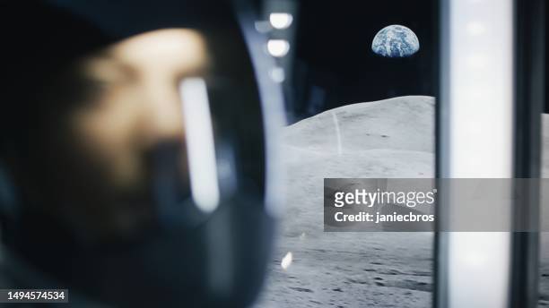 shaky moon rover trip over the surface of the moon. close-up astronaut looking out the window at distant planet earth - shaky stock pictures, royalty-free photos & images
