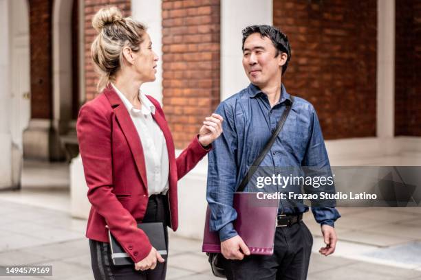 colleghi che parlano mentre camminano per la città - borsa messenger foto e immagini stock