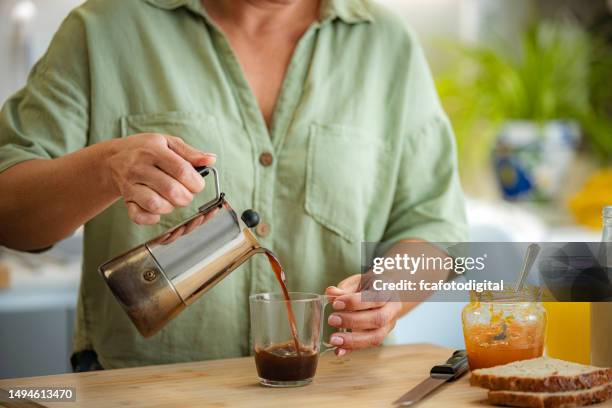 woman pouring coffee into cup - stovetop espresso maker stock pictures, royalty-free photos & images