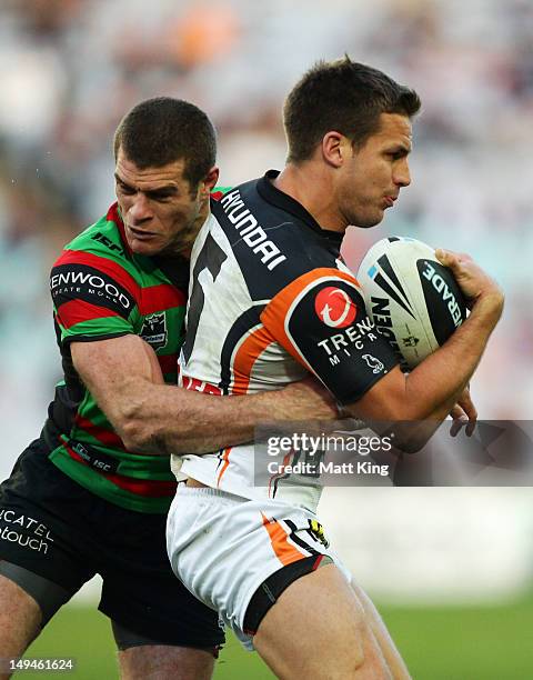 Beau Ryan of the Tigers is tackled by Matt King of the Rabbitohs during the round 21 NRL match between the South Sydney Rabbitohs and the Wests...