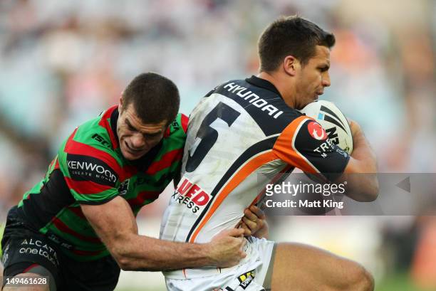 Beau Ryan of the Tigers is tackled by Matt King of the Rabbitohs during the round 21 NRL match between the South Sydney Rabbitohs and the Wests...