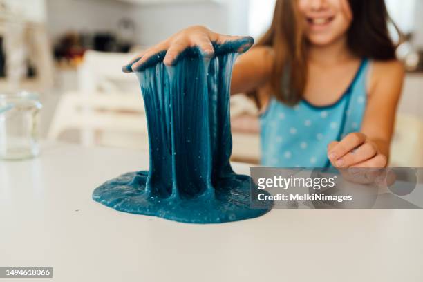 niña jugando con slime pegajoso - limoso fotografías e imágenes de stock