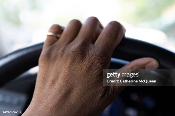 black woman’s hand on steering wheel - hand steering wheel stock pictures, royalty-free photos & images