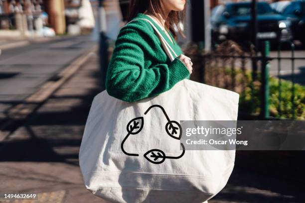 shopping with reusable bag to protect the environment - reusable bag stock pictures, royalty-free photos & images