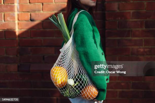 asian woman shopping with reusable bag to protect the environment - grocery store wall stock pictures, royalty-free photos & images