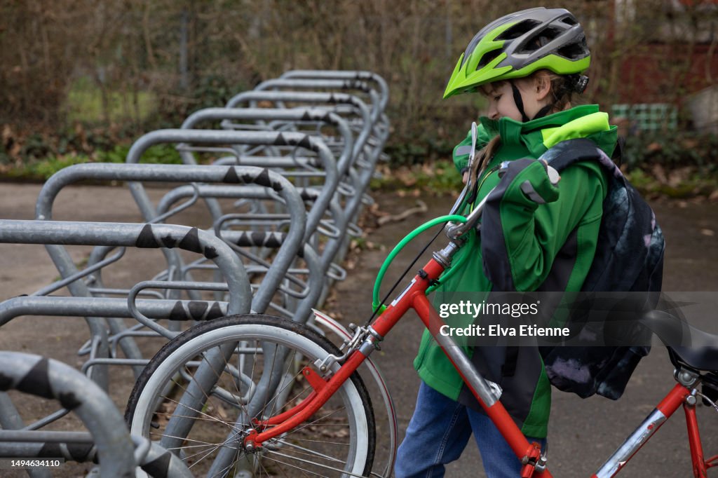Kid Racking A Bike Child Lifting A Bicycle Onto A Cycle Security Rack On A School Yard ...