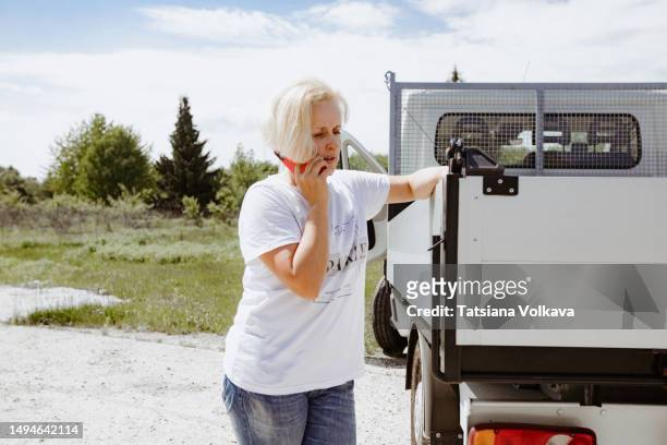 confident non-binary person standing by white truck while talking on phone - non motorised vehicle stock pictures, royalty-free photos & images