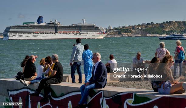 May 30: Tourists are seen at the Quiosque da Ribeira das Naus area as MS Arcadia, a 84,342 GT cruise ship in the P&O Cruises fleet, sails the Tagus...