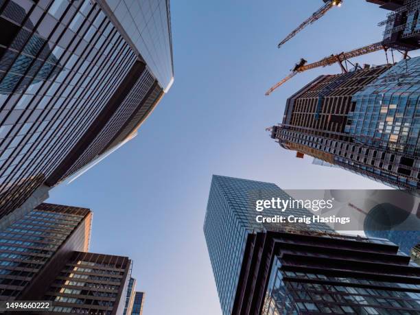 frankfurt germany - low angle view looking up at skyscrapers in the business and financial downtown district. concept piece for eu, engineering, business, office, finance, growth, trade and success themes. european union - toma de apertura fotografías e imágenes de stock