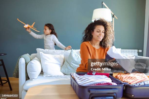 mother packing clothes in suitcase for a summer vacation - family summer holiday stock pictures, royalty-free photos & images