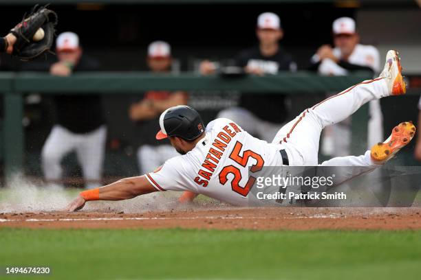 Anthony Santander of the Baltimore Orioles scores a run as he slides into home plate against the Cleveland Guardians during the second inning at...