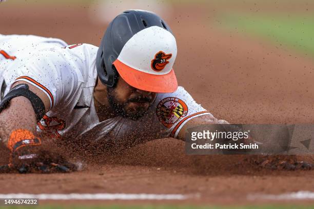 Anthony Santander of the Baltimore Orioles slides into second base after hitting an RBI triple to score three runs against the Cleveland Guardians...