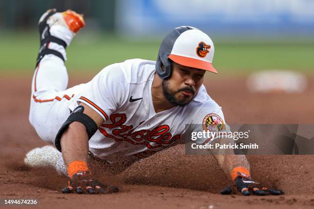 Anthony Santander of the Baltimore Orioles slides into second base after hitting an RBI triple to score three runs against the Cleveland Guardians...