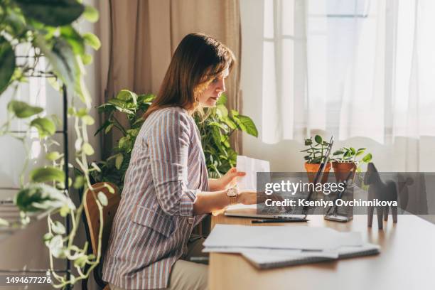 top view close up woman calculating bills, money, loan or rent payments, using laptop, online banking service, sitting at table, female holding receipt, planning budget, managing expenses, finances - wage stock-fotos und bilder