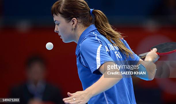 Anna Tikhomirova of Russia returns a shot to Tan Wenling of Italy during their table tennis women's singles preliminary round match of the London...