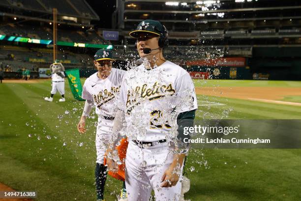 Jonah Bride of the Oakland Athletics is sprayed with water by Nick Allen after hitting a walk-off RBI single in the bottom of the ninth inning to...