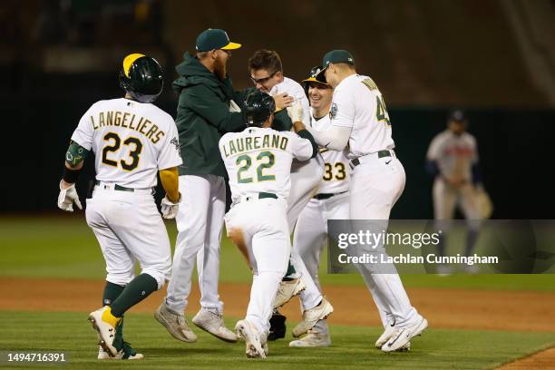 Jonah Bride of the Oakland Athletics celebrates with teammates after hitting a walk-off RBI single in the bottom of the ninth to defeat the Atlanta...