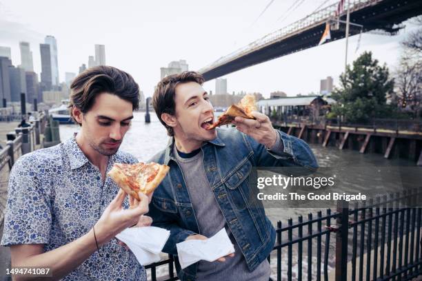 young men eating pizza while enjoying city break - panorama nyc day 2 foto e immagini stock