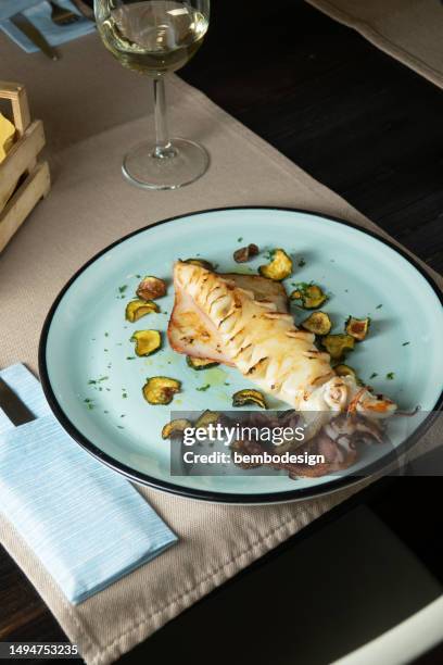 gegrillter tintenfisch auf dem tisch im restaurant - grilled squid stock-fotos und bilder