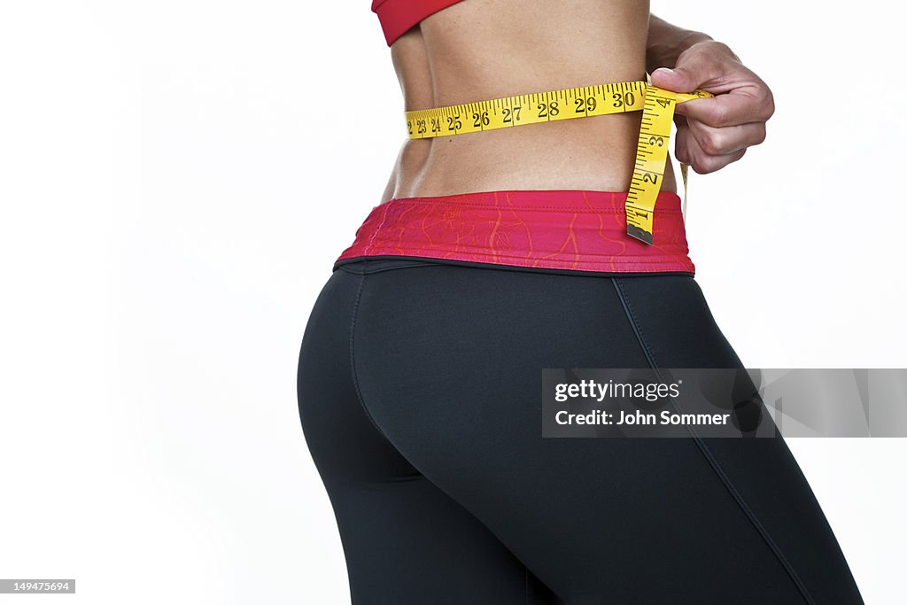 Woman measuring her waist