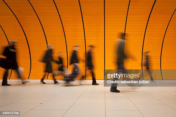 large group of people against modern orange subway tube - lange sluitertijd stockfoto's en -beelden