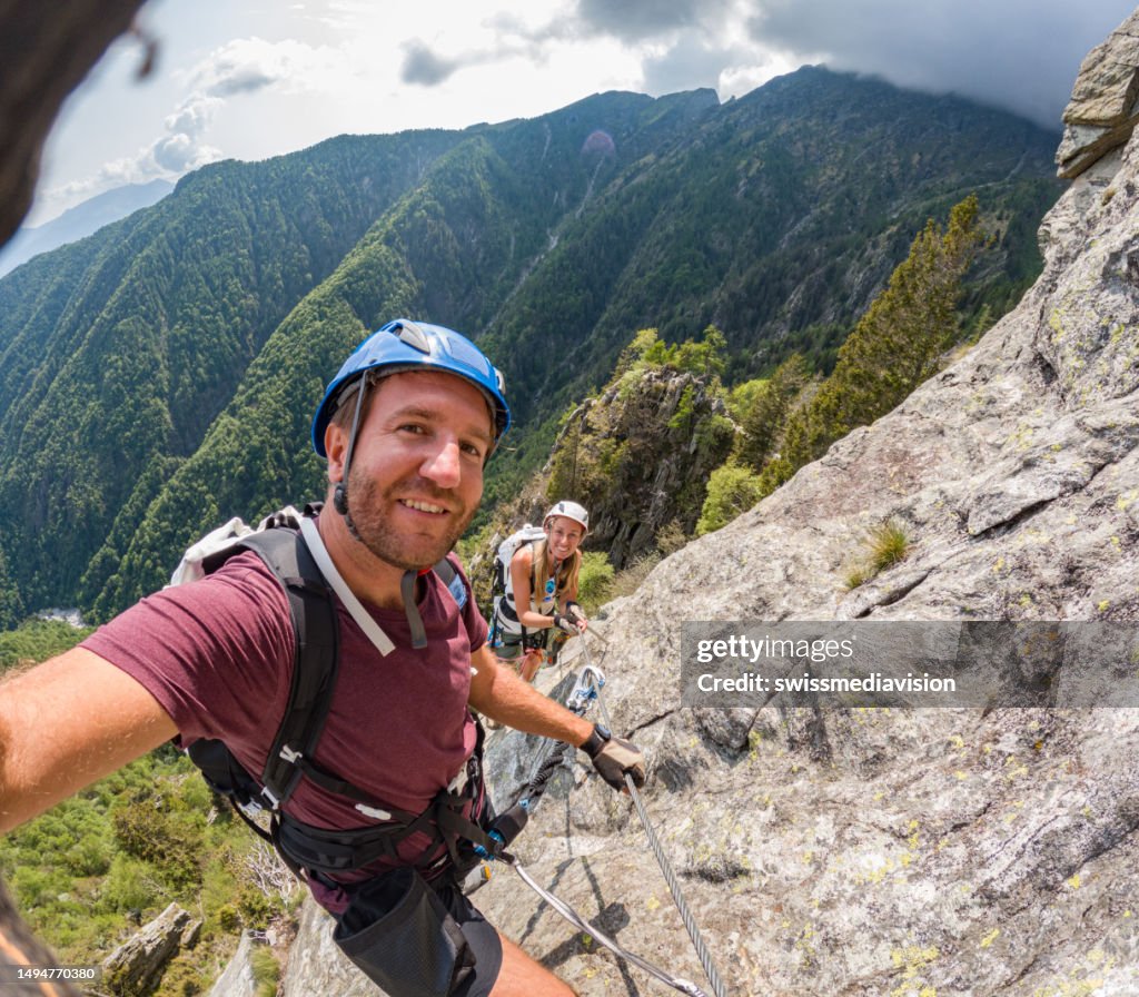 Coppia che scatta selfie durante l'attività di arrampicata su roccia