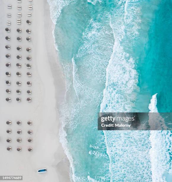 drone view of the sea and a beach with parasols lined up. - insel formentera stock-fotos und bilder