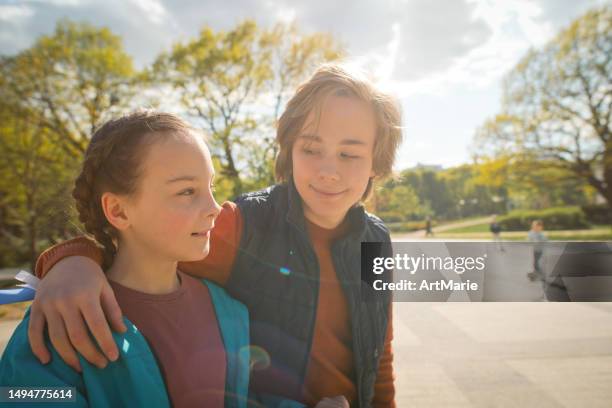 geschwister genießen sonnigen tag im frühling in einem park - teens brothers stock-fotos und bilder