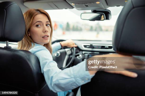female driving in reverse - reversing stock pictures, royalty-free photos & images