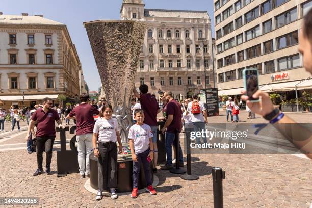 Fans celebrate near replica trophy near the Szent István-bazilika prior to the UEFA Europa League 2022/23 final match between Sevilla FC and AS Roma...