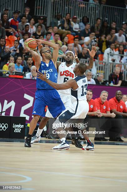 Tony Parker of France passes against LeBron James and Chris Paul of the USA Mens Senior National team at the Olympic Park Basketball Arena during the...