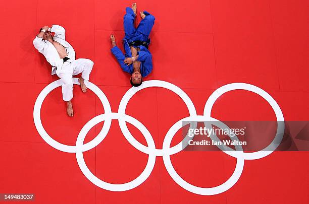 Pawel Zagrodnik of Poland and Masashi Ebinuma of Japan lay on the mat after their match in the Men's -66 kg Judo on Day two of the London 2012...