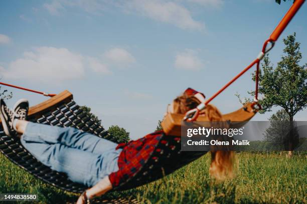redhead woman relaxing in hammock outdoors. beautiful green field - hanover germany bildbanksfoton och bilder