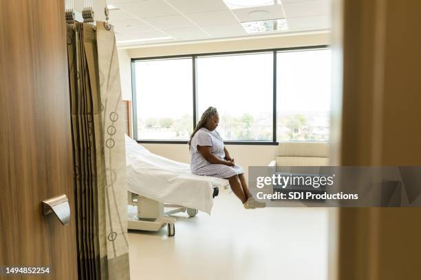 mature woman waits in the hospital room alone - hospital curtain stock pictures, royalty-free photos & images