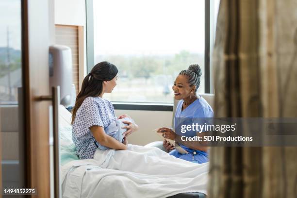 pediatrician meets the new baby - mid wife stock pictures, royalty-free photos & images