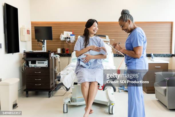 new mother smiles while talking with the female doctor - obstetrician 個照片及圖片檔