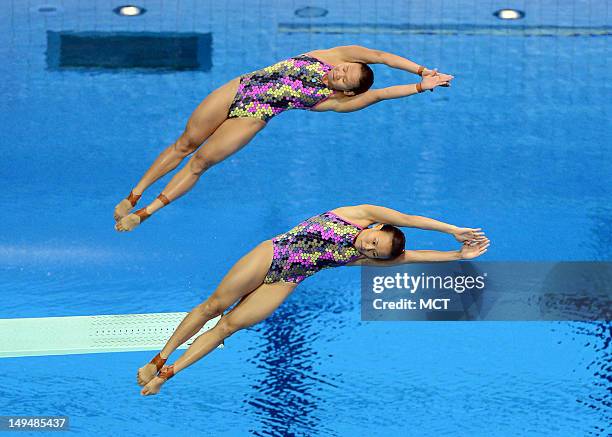 Malaysian divers Pandelela Rinong Pamg and Jun Hoong Cheong launch into a back one and a half somersault and half twist during the finals of the...