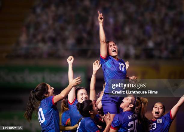 celebrating women soccer players raise up their teammate after winning - mannschaftssport stock-fotos und bilder