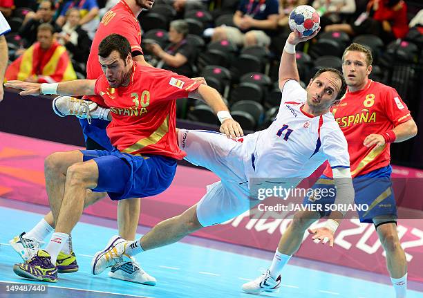 Serbia's Alem Toskic jumps to shoot as he vies with Spain's pivot Gedeon Guardiola Villaplana during the men's preliminaries Group B handball match...